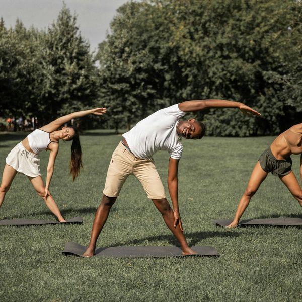 Diverse group of smiling people with yoga mats.